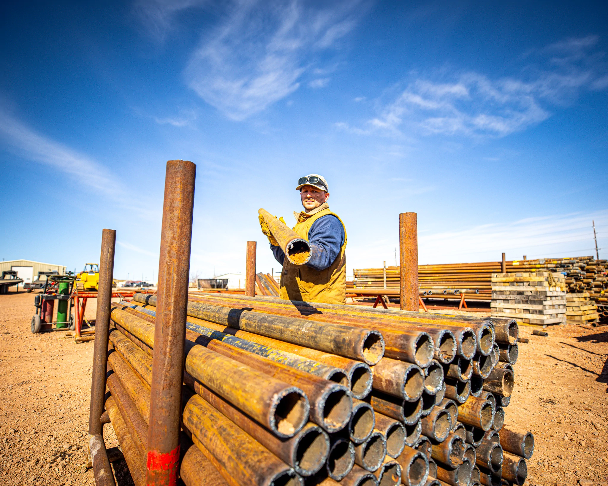 WYO Services crew member at the pipe yard with Wyoming sky