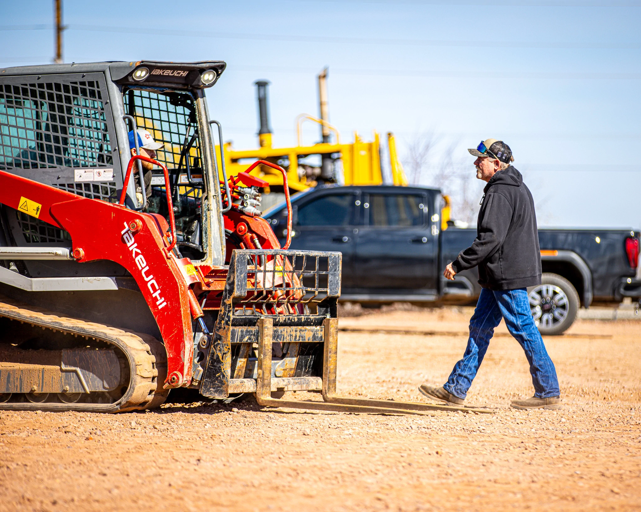 Worker approaching Takeuchi skid steer in the WYO Services yard