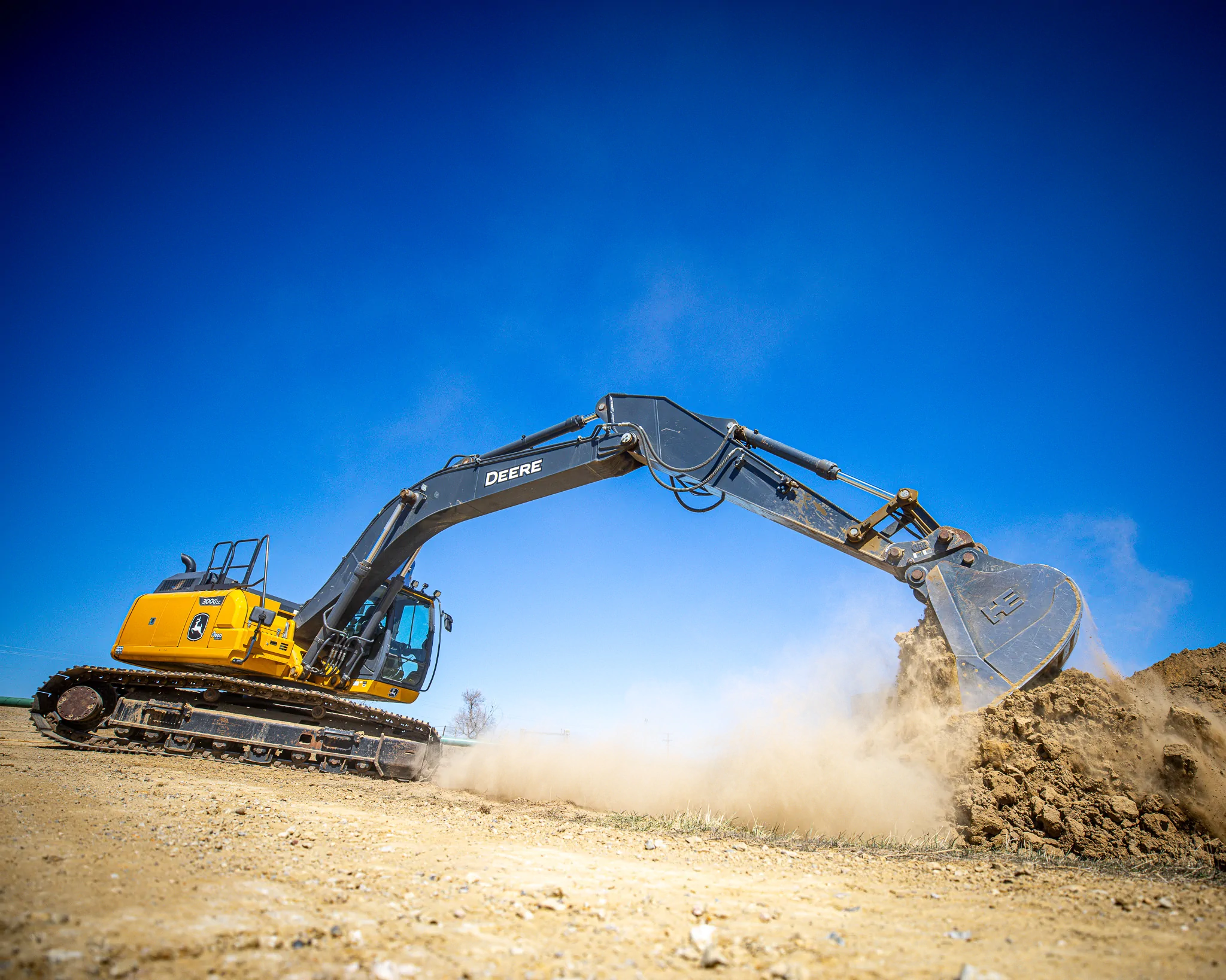John Deere excavator moving earth on a WYO Services pad construction site