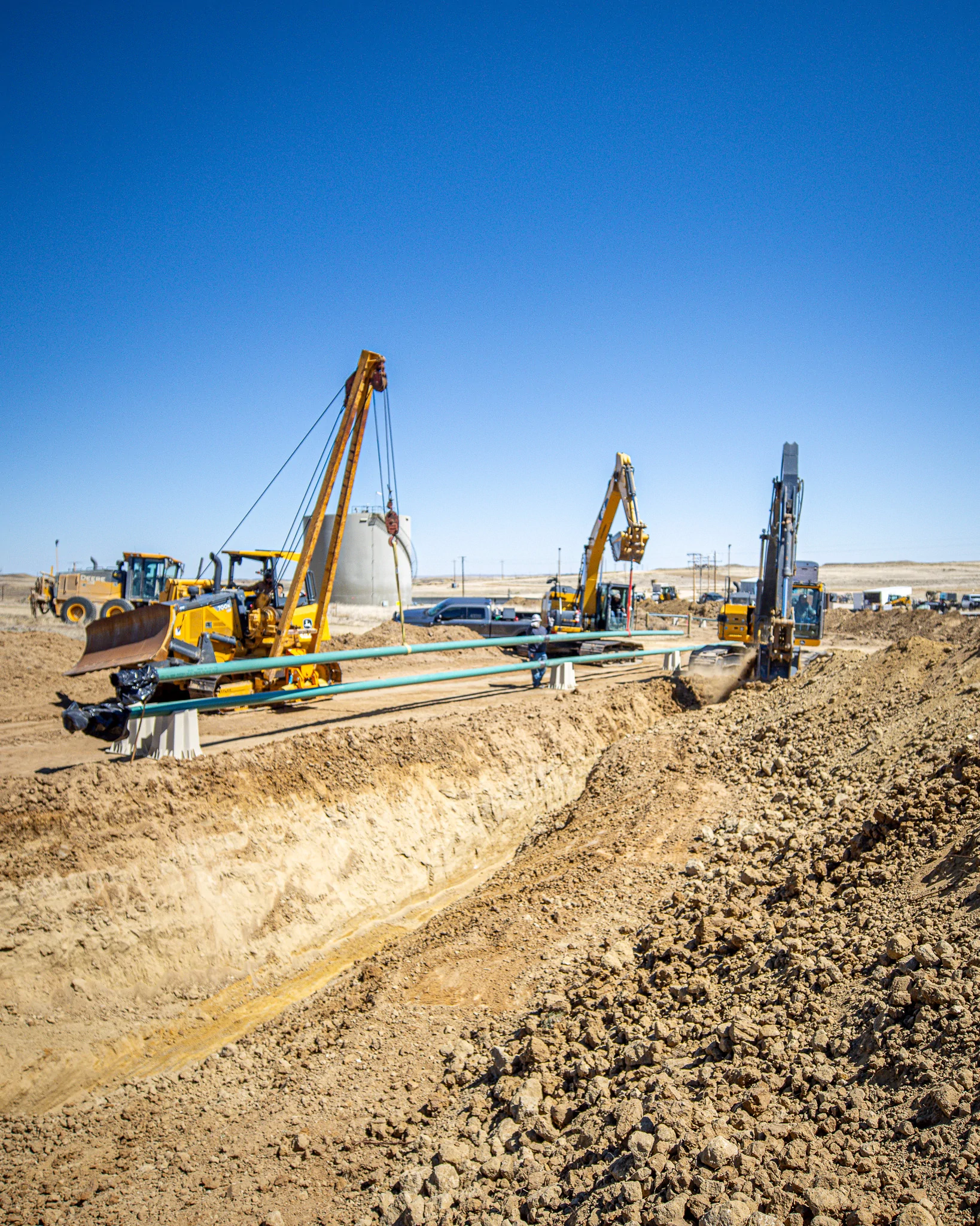 Gravel access road under construction in a rural oilfield setting